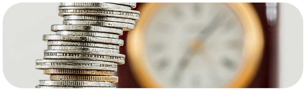 Moedas empilhadas ao lado de um relógio, representando o tempo de espera para o pagamento de RPV e precatório.